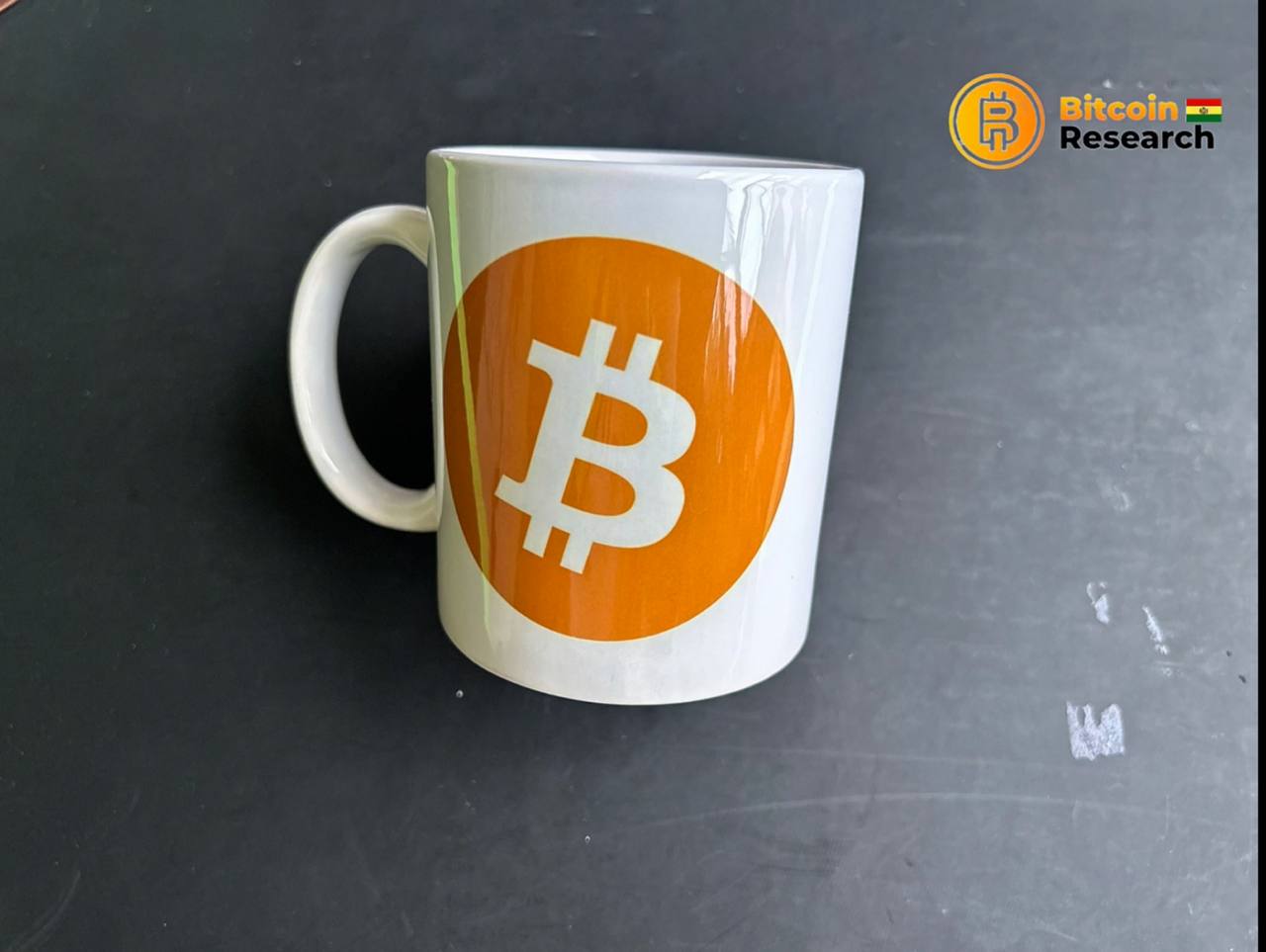 Tasa blanca con logo de Bitcoin